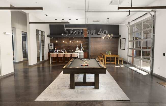 a game room with a pool table and a bar