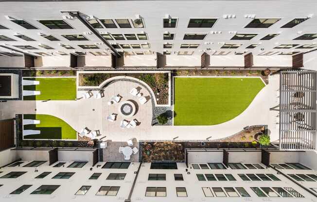 A modern building with a green lawn and a white circular design on the wall.