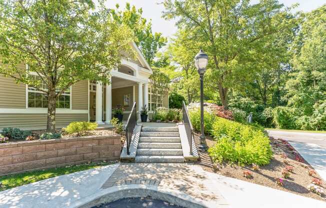 a front porch with stairs and a house with trees