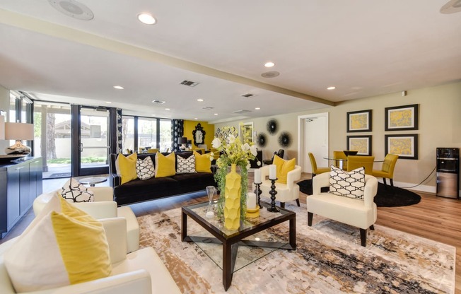 Community leasing office with bright yellow accessories, pillows, and chairs.  There are many seating options and desks.