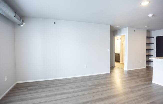 Empty living room with large, bright windows.