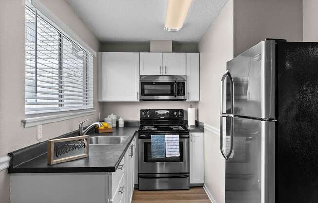 A modern kitchen with a black fridge and stove.