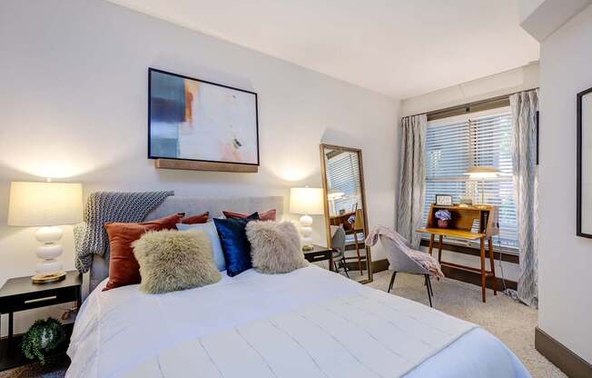 A bedroom with a large bed and a painting on the wall.