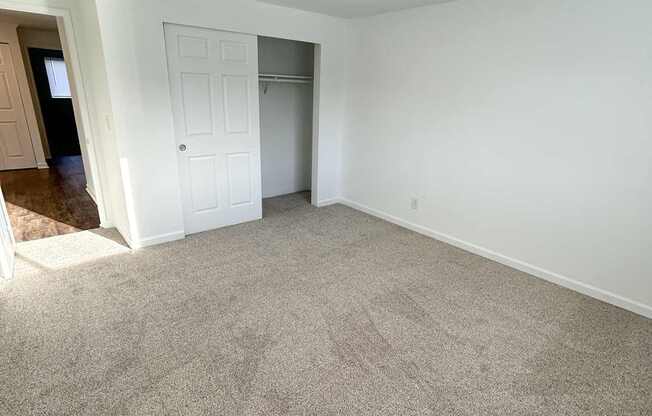 A room with a carpeted floor and a white door.