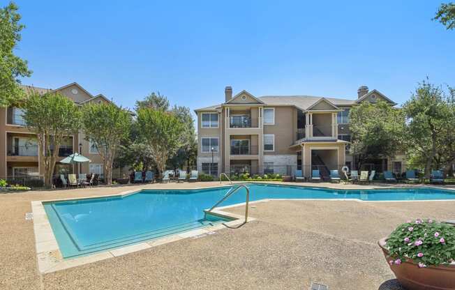 a swimming pool with an apartment building in the background