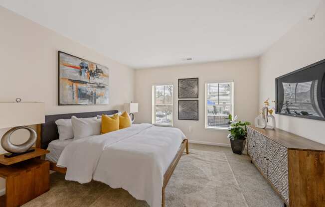 a bedroom with white bedding and yellow pillows