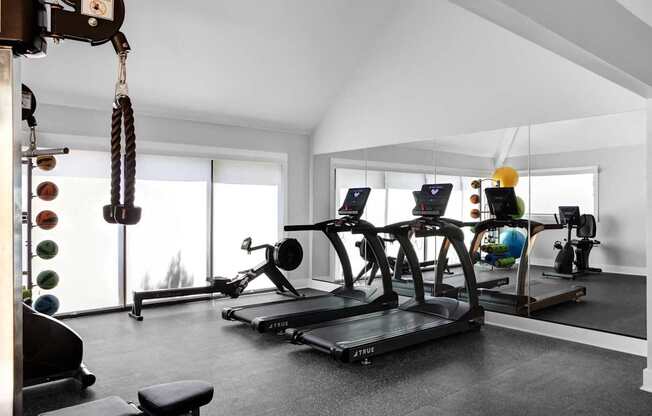 a gym with treadmills and other workout equipment in a home