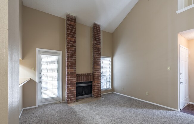 A room with a fireplace and two windows.