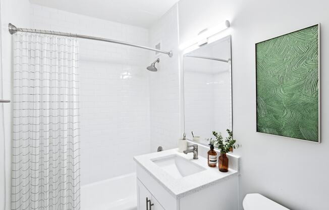 a white bathroom with a shower and a sink