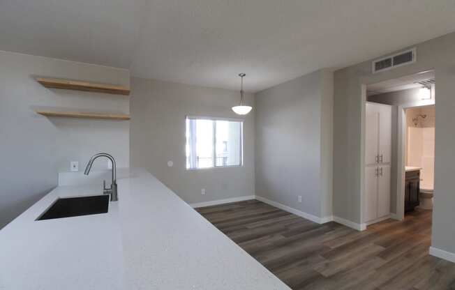 a kitchen and living room with a sink and a window