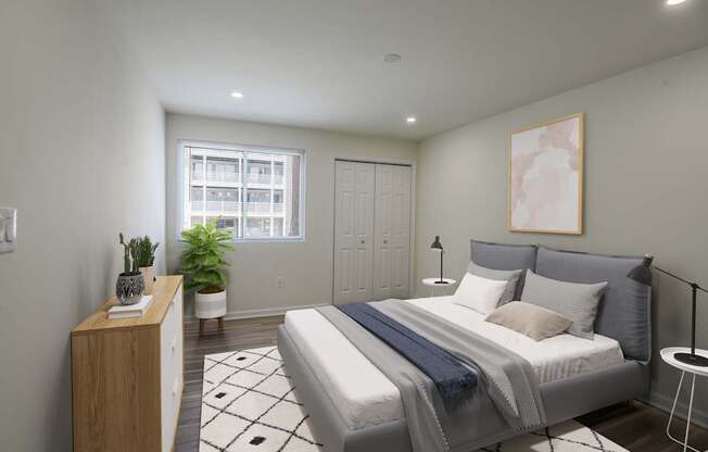 A bedroom with a bed, nightstand, and a plant.