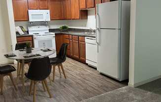 a kitchen with white appliances and wooden cabinets