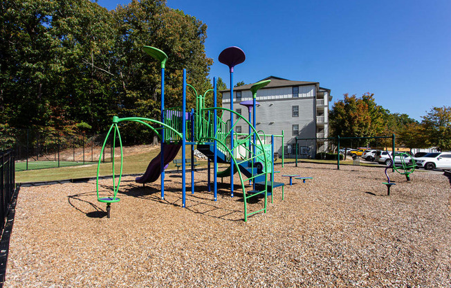 a playground at a park with a building in the background