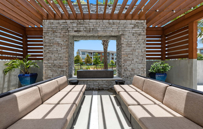 A patio with a stone wall and wooden slats on the sides.