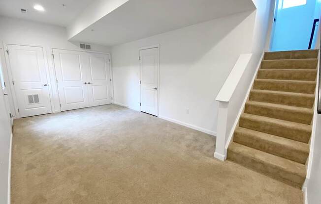 A spacious room with a staircase and built-in closets.