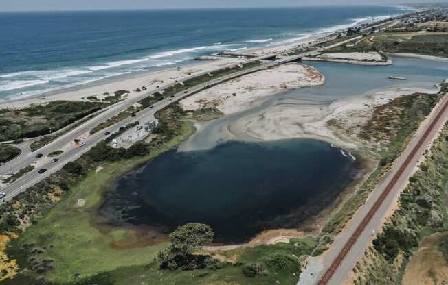 an aerial view of a body of water next to a highway and the ocean