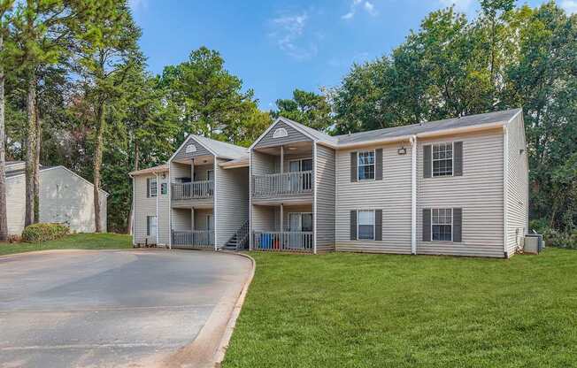 A large two-story apartment building with a driveway in front.