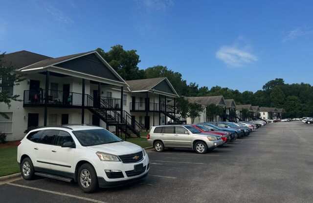 A white SUV is parked in a parking lot in front of a building.