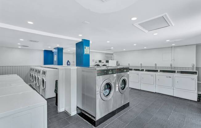 a large laundry room with washers and dryers and a row of washing machines