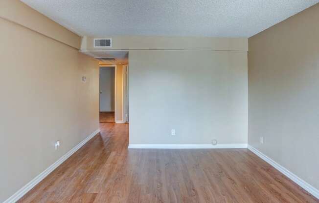 the living room and dining room of an empty house with wood floors