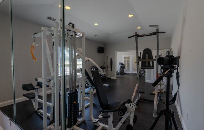 a gym with weights equipment and mirrors in a home