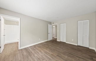 an empty living room with wood flooring and white walls