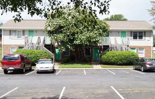 an apartment building with cars parked in a parking lot