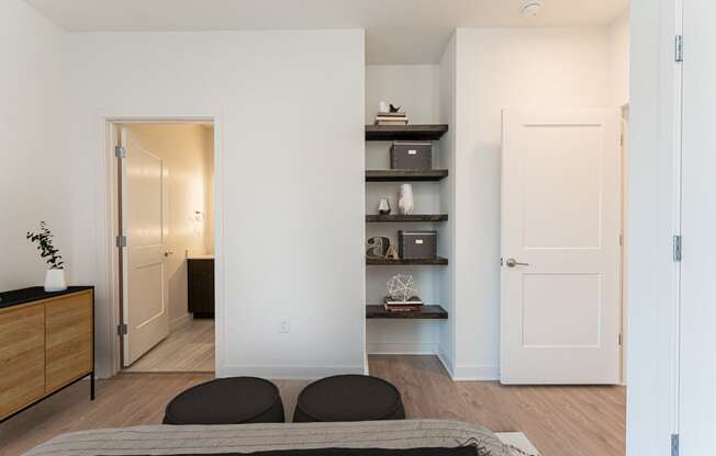 a bedroom with white walls and a bed with two black pillows at The Box, Richmond, 23224