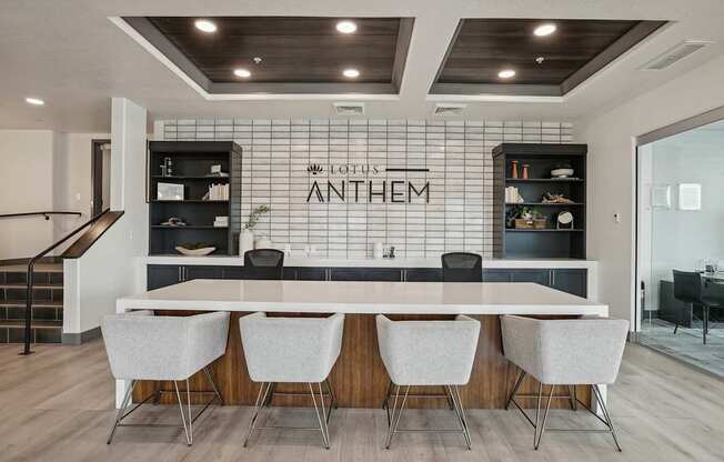 A modern kitchen with a white countertop and chairs.
