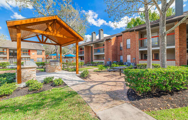 A wooden pavilion is in front of apartment buildings.