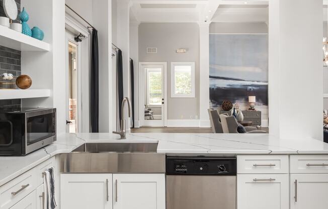 a kitchen with white cabinets and a stainless steel sink
