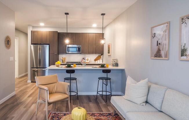 Spacious living room with open concept designer kitchen, espresso cabinetry, and stainless steel appliances.