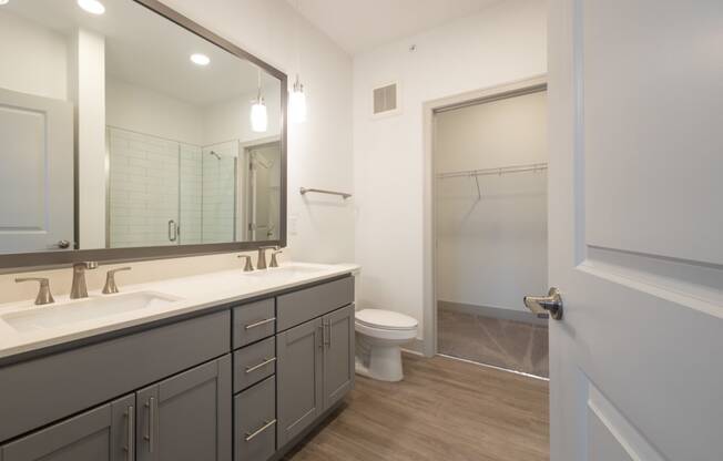 a bathroom with a large mirror and a toilet and a shower