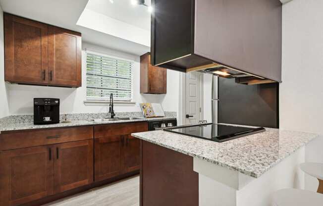 a kitchen with granite counter tops and wooden cabinets