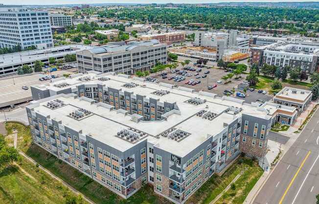 an aerial view of a large building with a parking lot in front of it