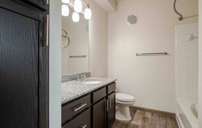 a bathroom with a toilet, sink and bathtub at Parc at Bentonville Apartments in Bentonville, AR