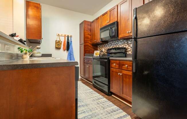 a kitchen with black appliances and wood cabinets