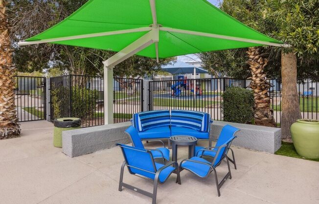 a patio with a table and chairs and a green umbrella
