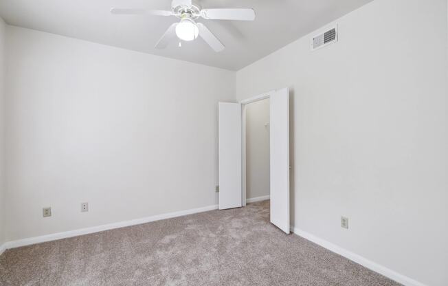 an empty room with white walls and a ceiling fan at St. Augustine Estate, Dallas