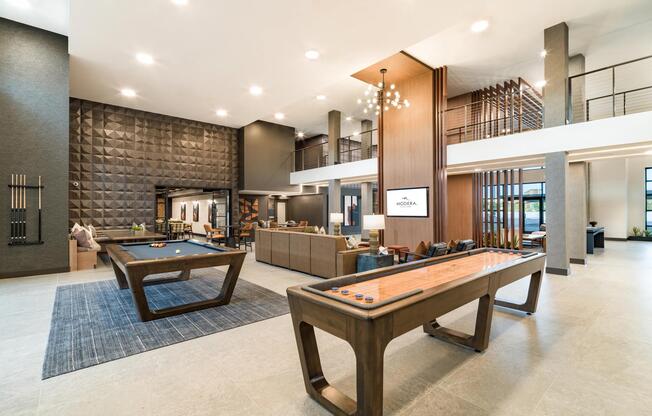 A spacious clubroom with game tables, lounge seating, and seamless indoor-outdoor flow.