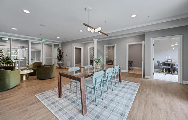 Collaborative workspace with a shared worktable, lounge seating, and nearby meeting rooms designed for productivity, connection, and flexible workdays.