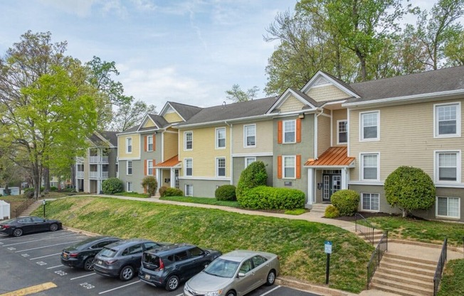 Apartment complex with a parking lot in front.