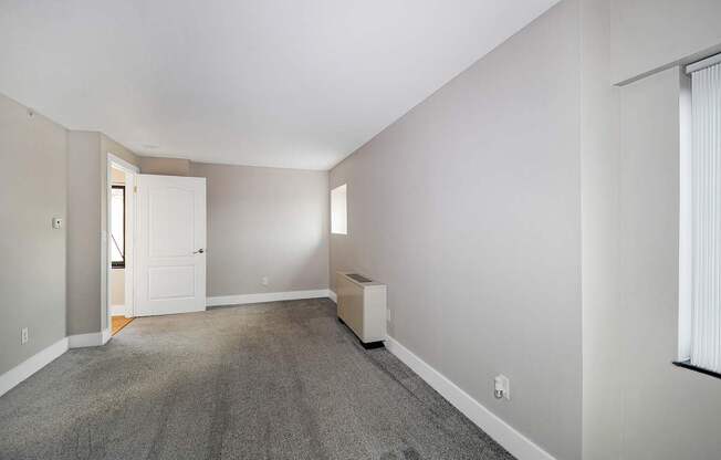 A room with a carpeted floor and a white door.