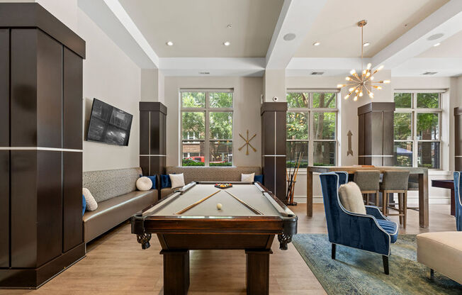 a living room with a pool table and a dining room