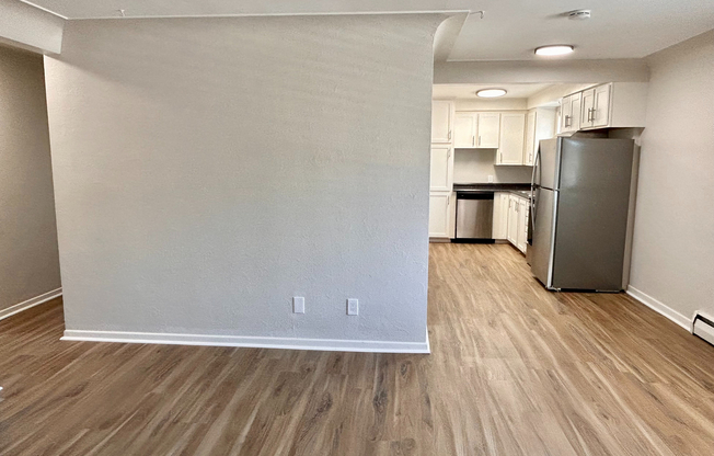 Modern open-plan kitchen area with sleek stainless steel appliances and warm wood flooring, perfect for contemporary living.