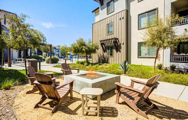 A patio with chairs and a table in front of a building.