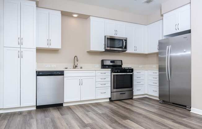 a kitchen with white cabinets and stainless steel appliances