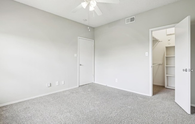 A2 floor plan bedroom with a  walk-in closet and a ceiling fan at Jefferson Creek Apartments in Irving, TX.