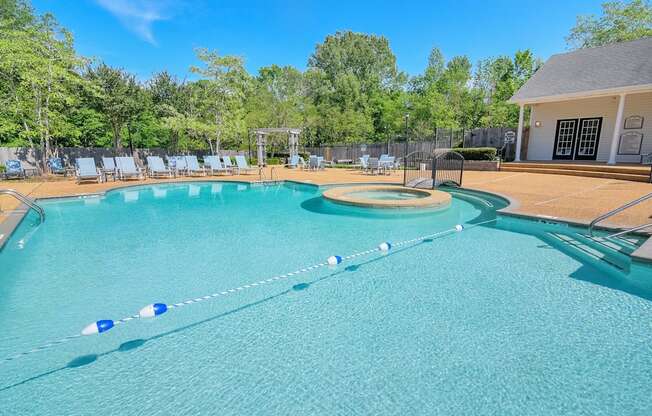 a large pool with chairs and a house in the background at Reserve of Jackson Apartment Homes, Jackson, Mississippi