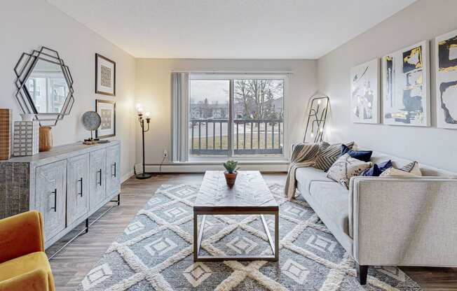 a living room with couch, table and large sliding glass door to balcony